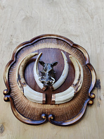 Клыки кабана на резном медальоне